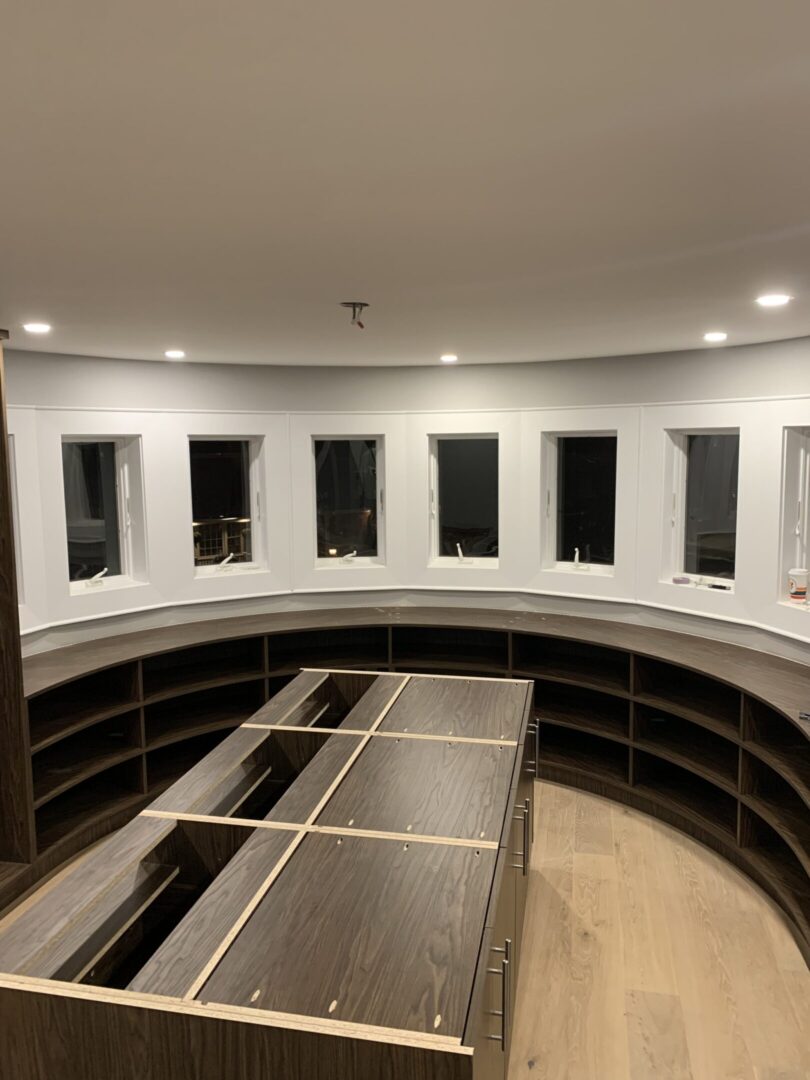 Curved room with shelves and windows.