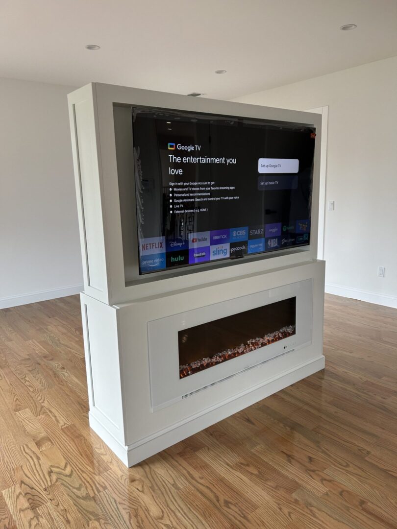 TV on white stand with electric fireplace.