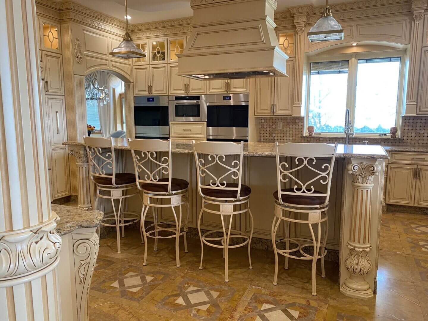 Elegant kitchen with ornate bar stools and classic cabinetry.