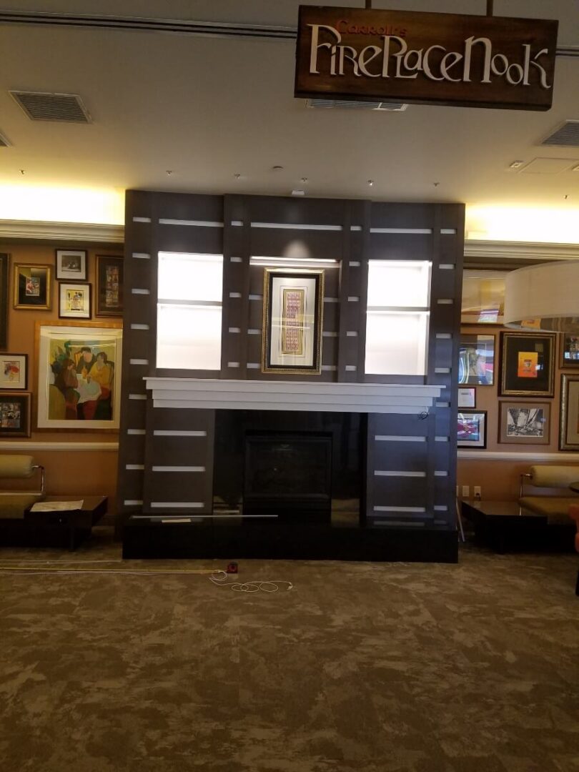 A cozy lounge area with framed artwork and a fireplace.