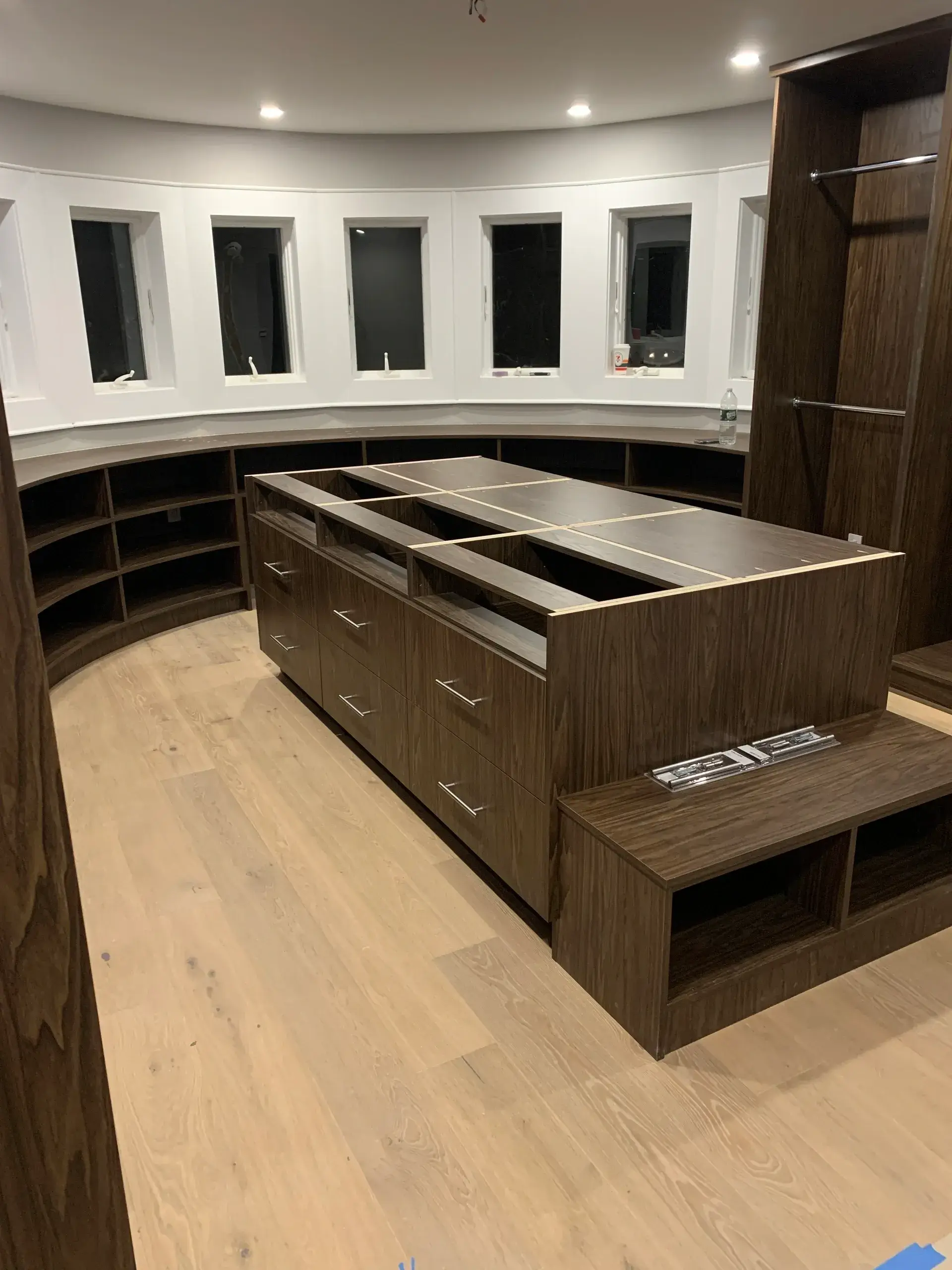 Modern walk-in closet with wooden cabinetry.