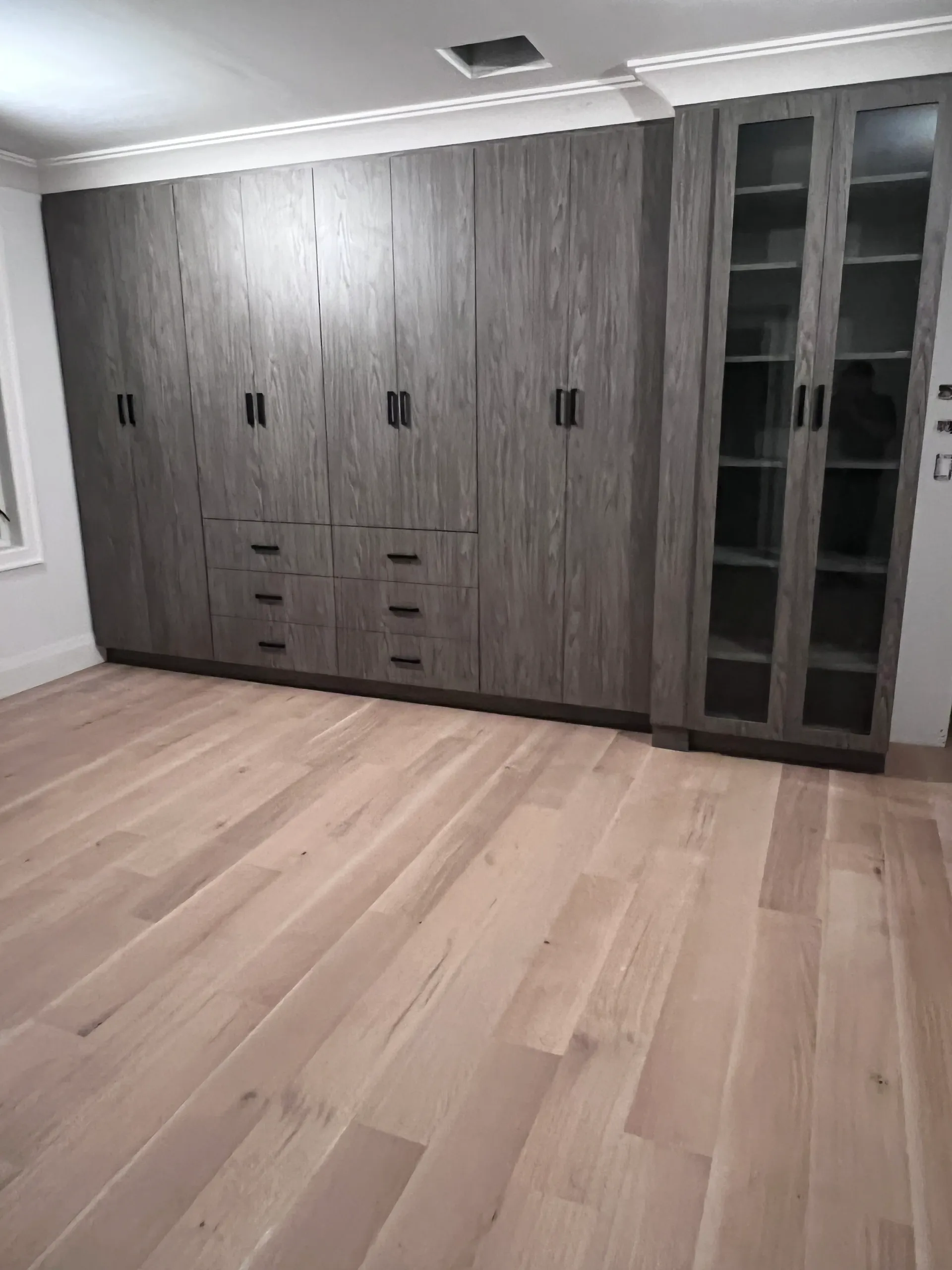 Wooden wardrobe and cabinets in empty room.