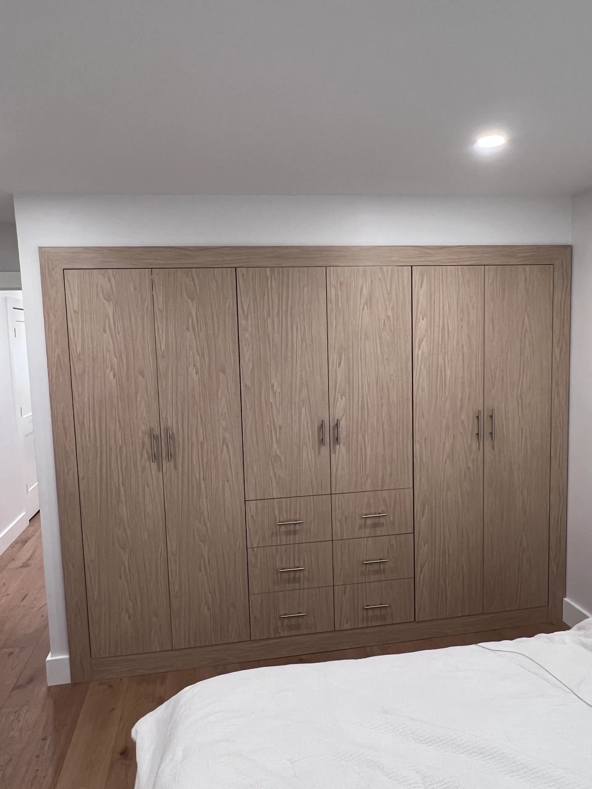 Wooden wardrobe with drawers in bedroom.