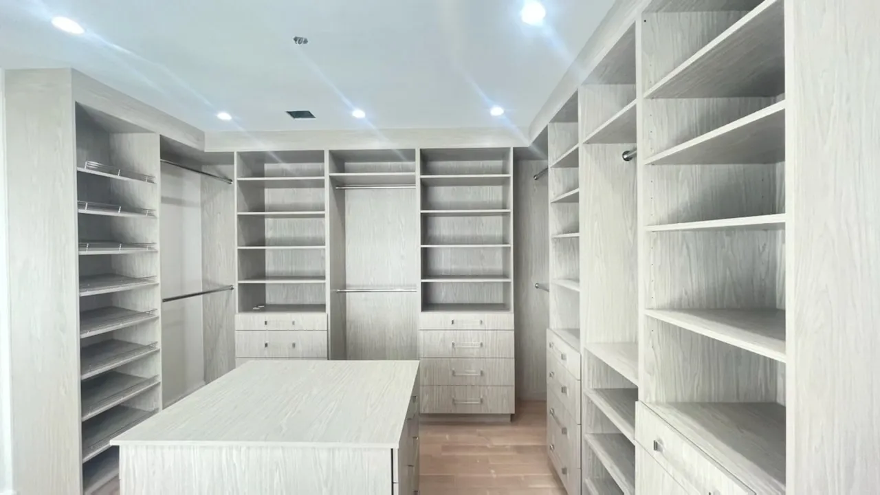 Spacious walk-in closet with wooden shelves.