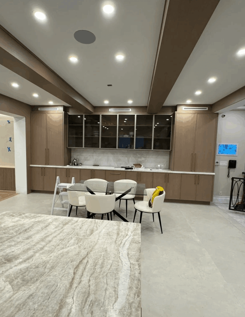 Modern kitchen with dining area and lighting.