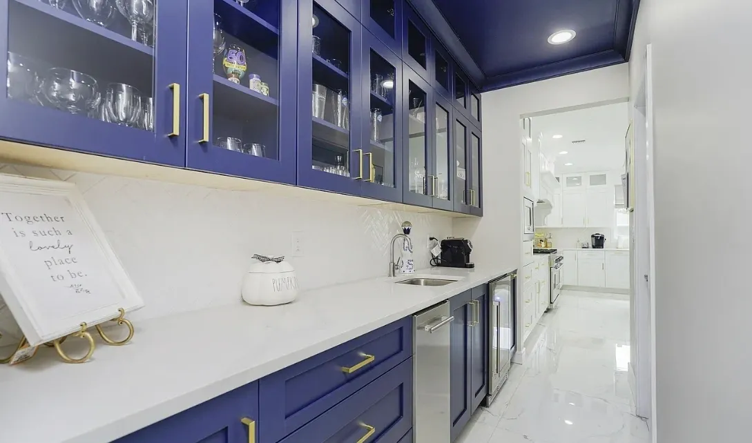 Navy blue kitchen with white marble floor